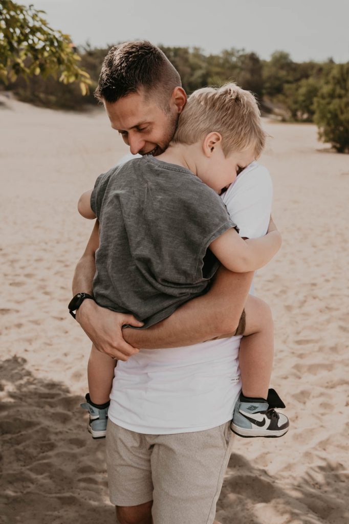 Vader en zoon knuffelend op de Veluwe vaderliefde
